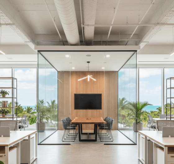 Modern office with coastal-inspired decor, light wood finishes, comfortable seating, and glass treatment rooms, designed in a Florida style.